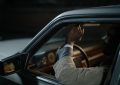 Un homme ajuste le rétroviseur depuis le siège du conducteur
