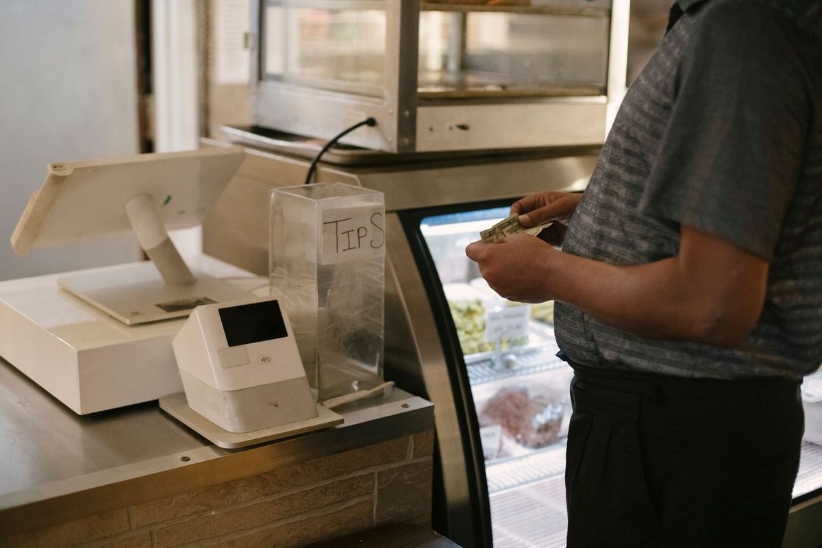 Homme payant à une borne de caisse dans un restaurant Homme payant à une borne de caisse dans un restaurant